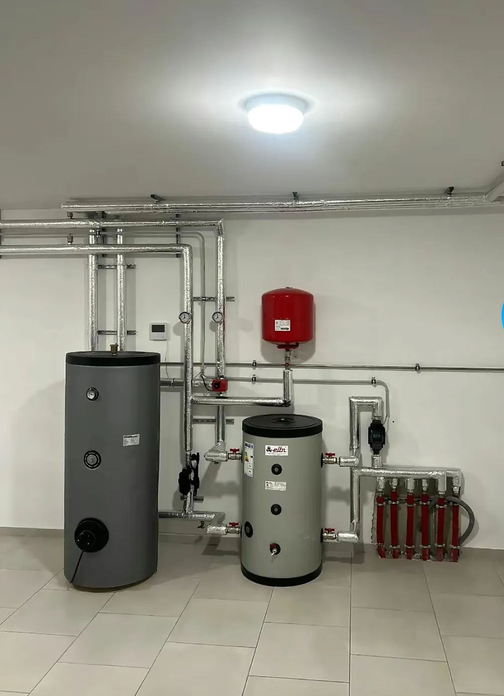 Sauberer Technikraum mit Speicher, Ausdehnungsgefäß und isolierten Rohren