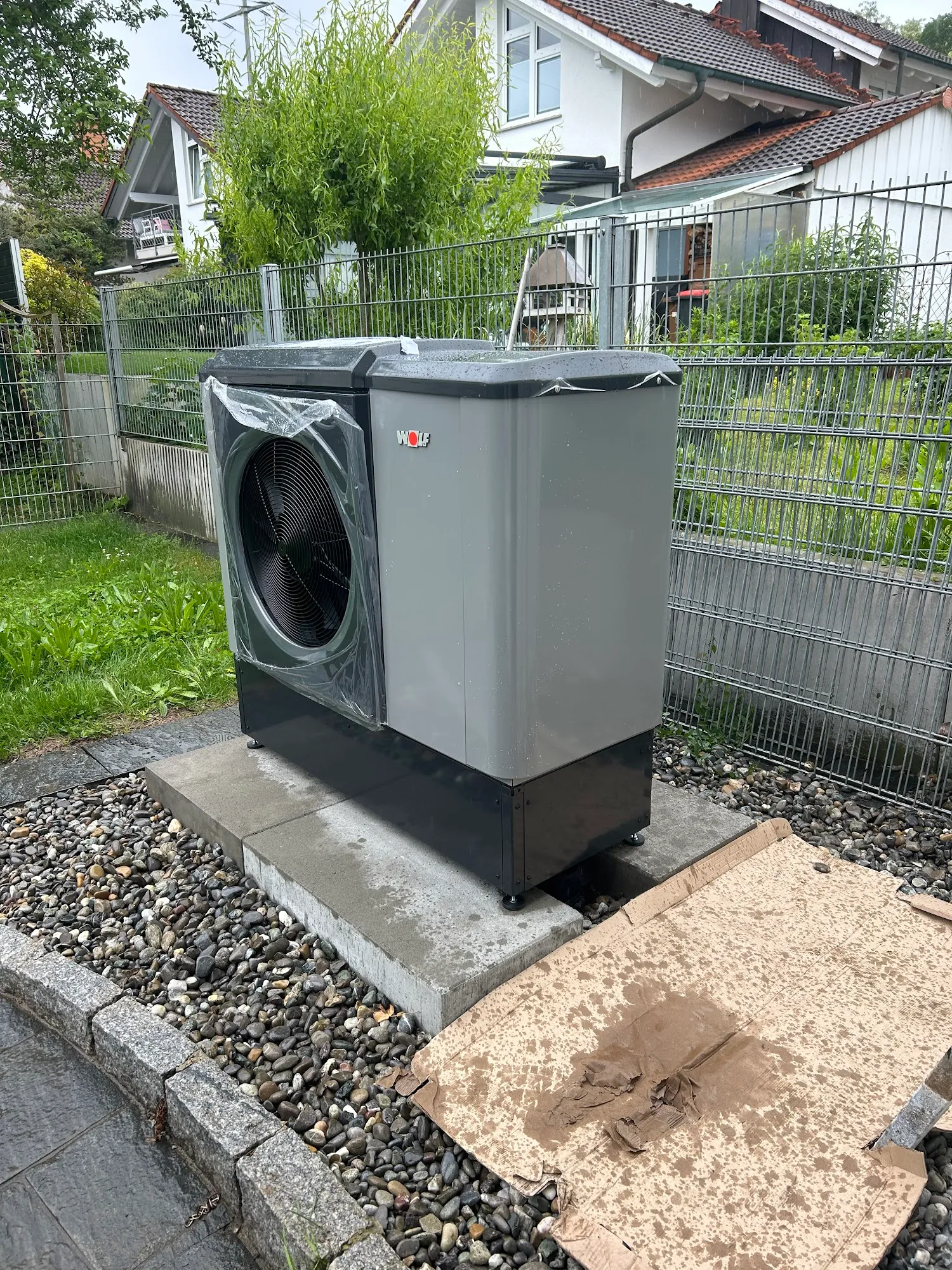 Graue Wolf Wärmepumpe im Außenbereich auf einem Kiesbett